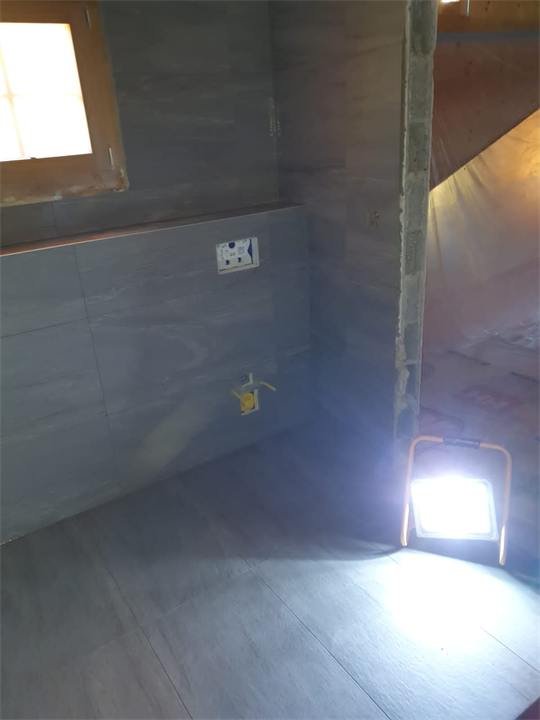 Douche à l'italienne en cours de finition, carrelage gris