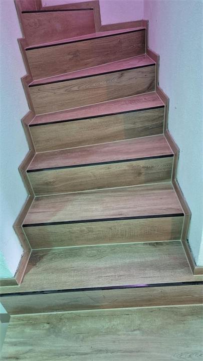 Escalier en carrelage effet chêne avec profilés de nez de marche
