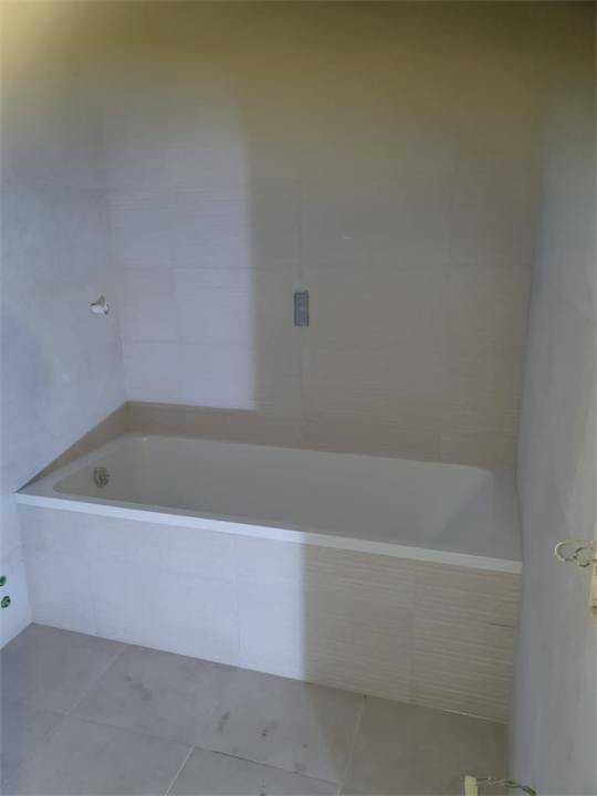 Salle de bain en faïence claire avec baignoire
